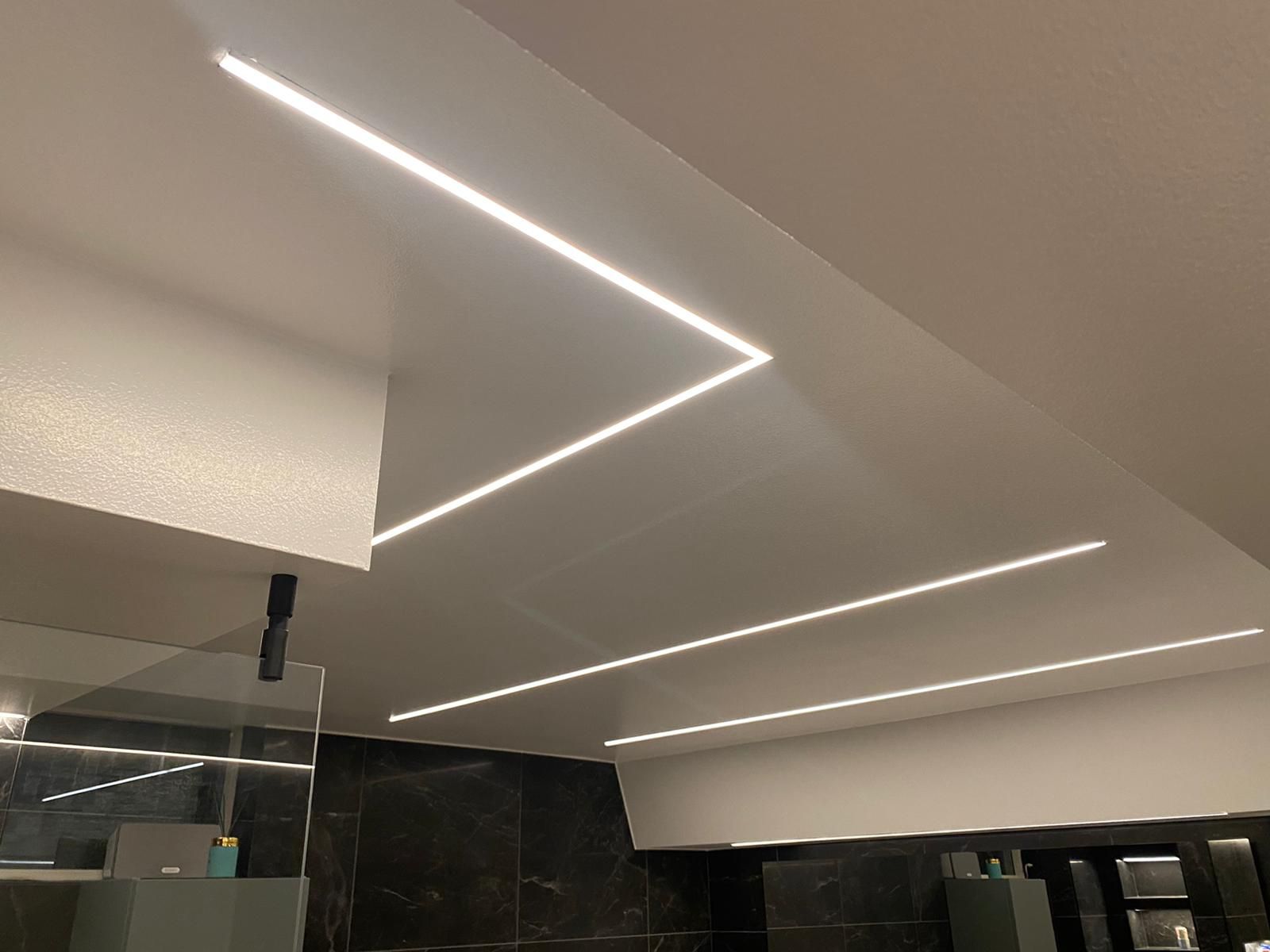 Recessed LED ceiling lighting in a marble tile bathroom
