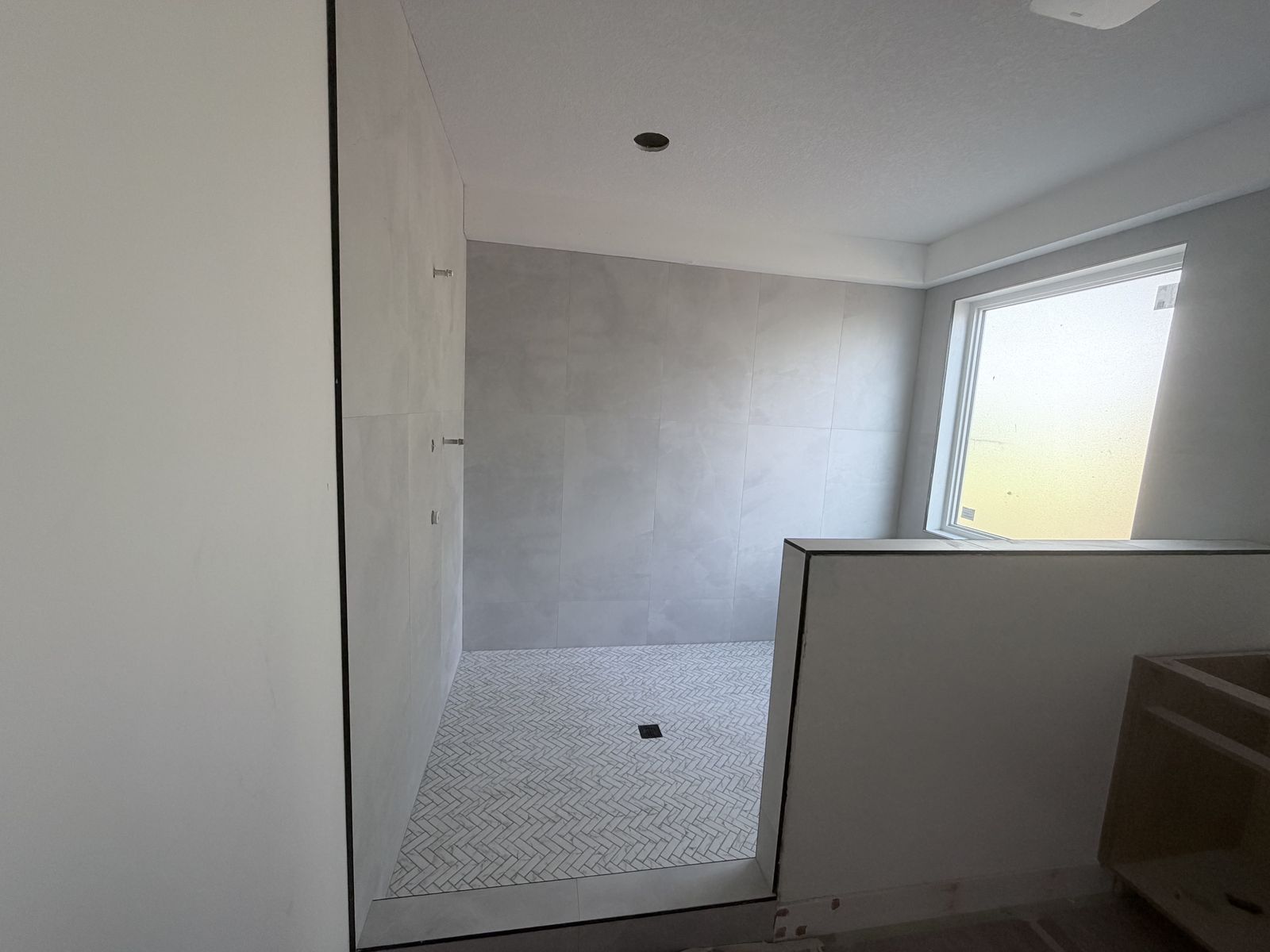 Gray tile shower with herringbone floor