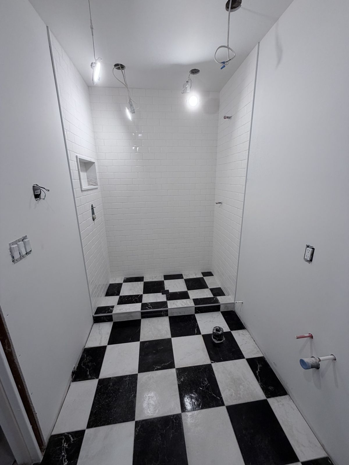 White subway tile shower with checkerboard floor